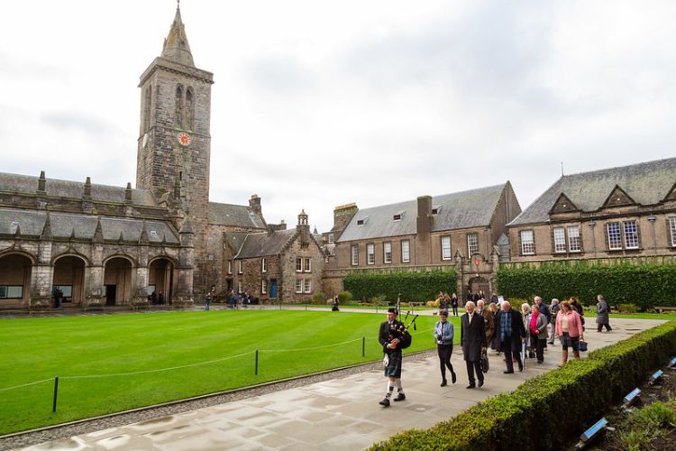 The historic quad at the University of St Andrews, with a piper leading a small group in a procession